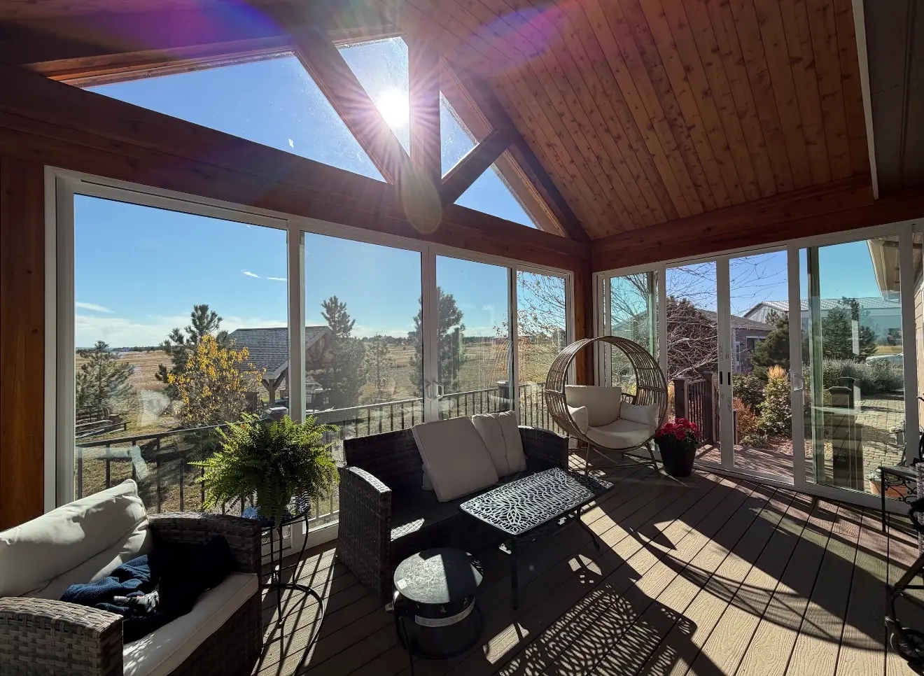 Interior view of elevated sunroom with sunlight and seating in Elizabeth, Colorado