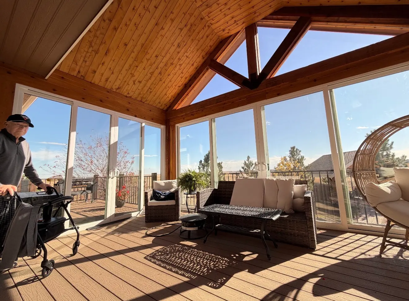 Interior view showing panoramic glass walls and deck access in elevated sunroom in Elizabeth, Colorado