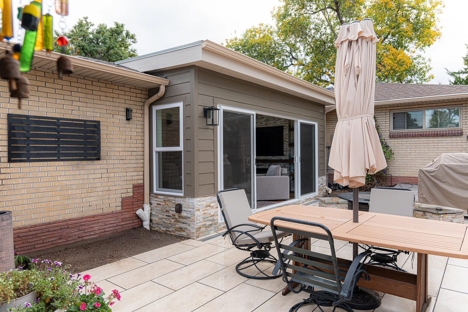 Sunroom addition connected to the existing house and paved backyard patio