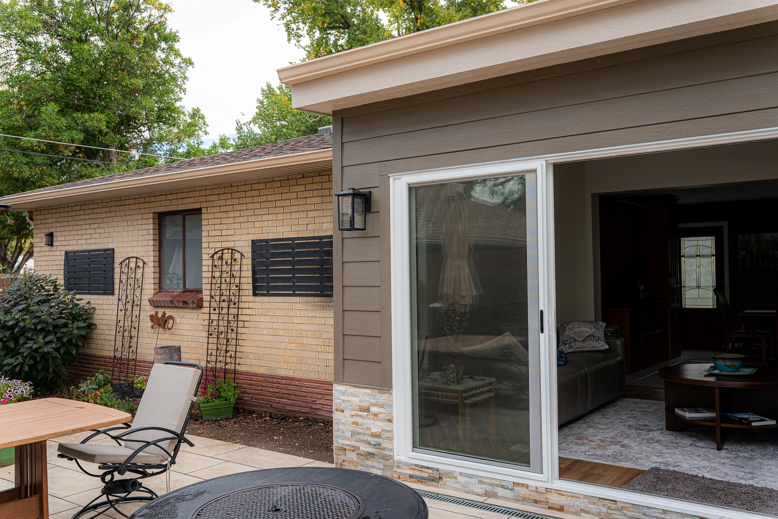 Contemporary exterior finishes and sliding door on the completed flat roof sunroom