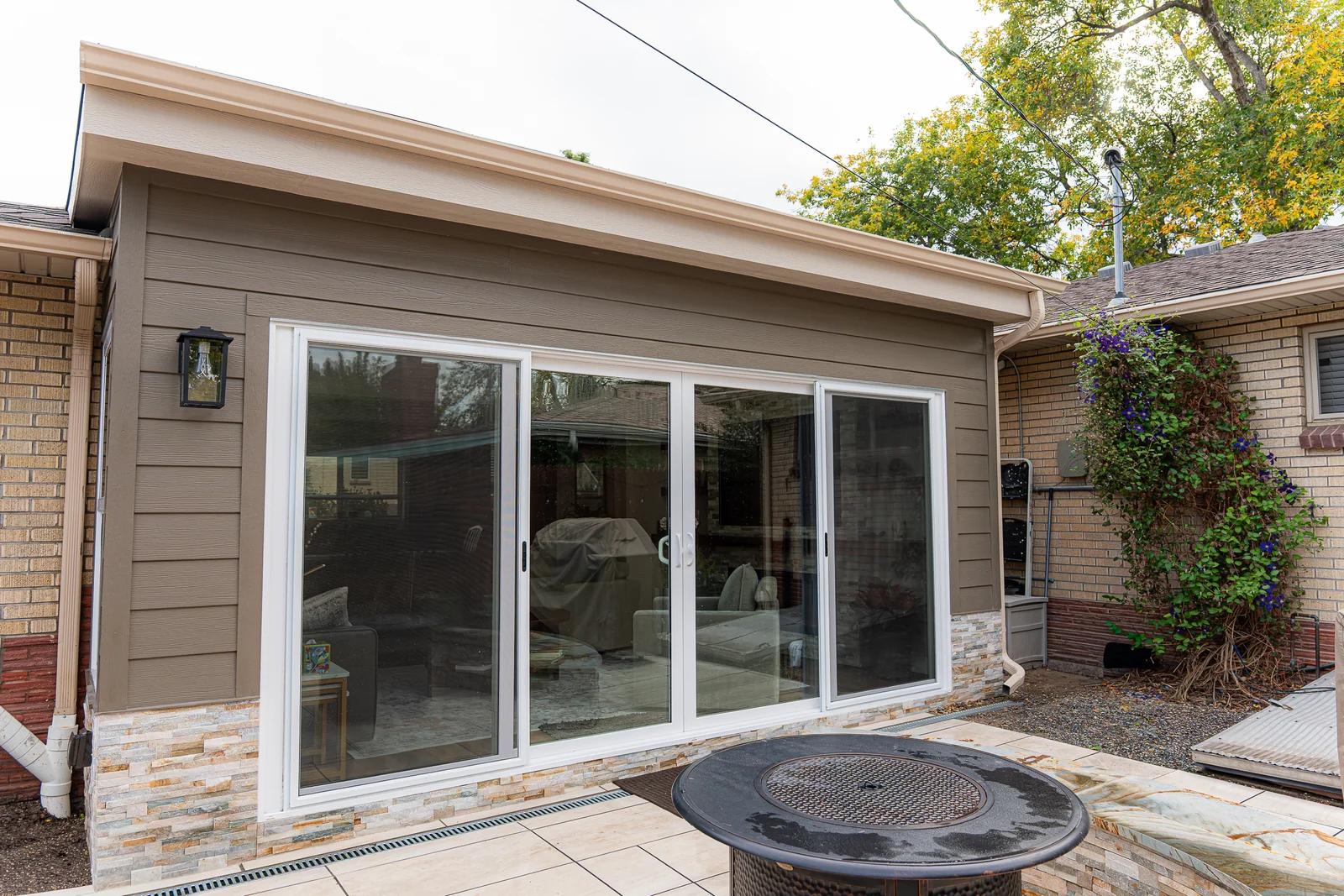 Flat roof sunroom with a four-panel sliding glass door in Englewood, Colorado