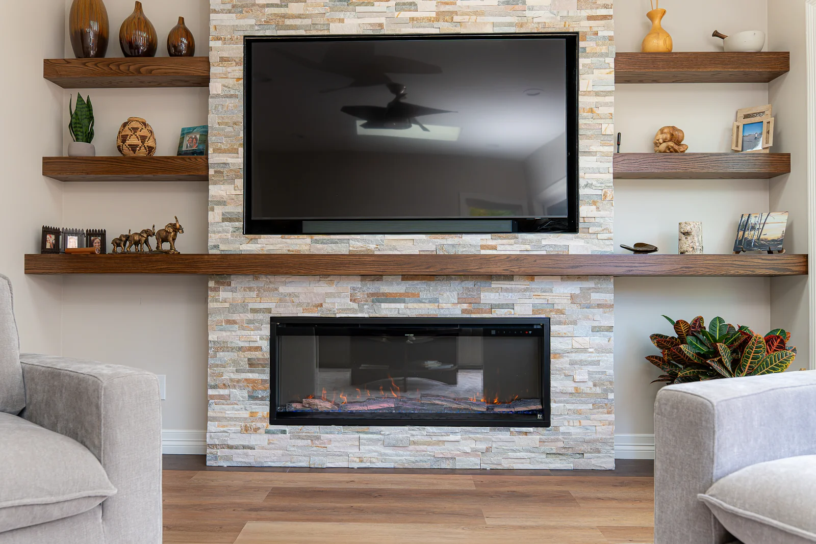 Stone fireplace wall with a television and built-in shelving