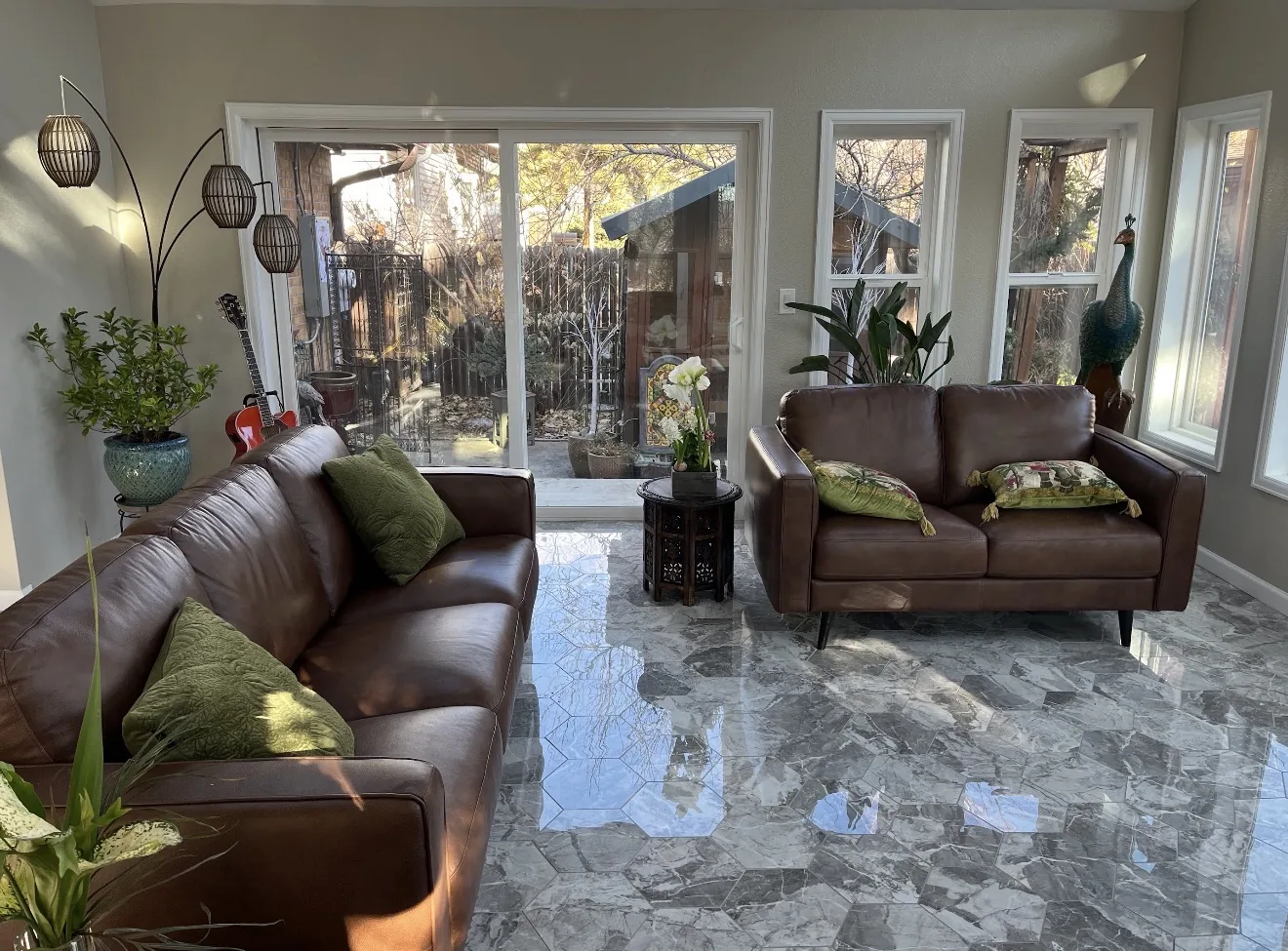 Finished Lakewood sunroom living space with sofas, sliding glass door, and tile floor