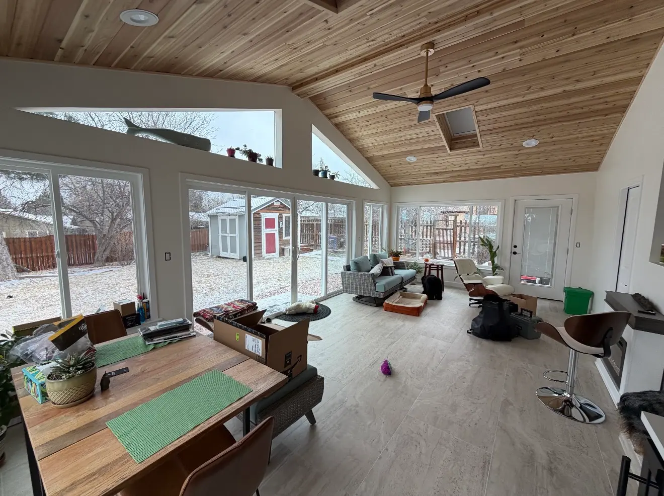 Interior of completed sunroom with large windows and vaulted wood ceiling in Boulder, Colorado